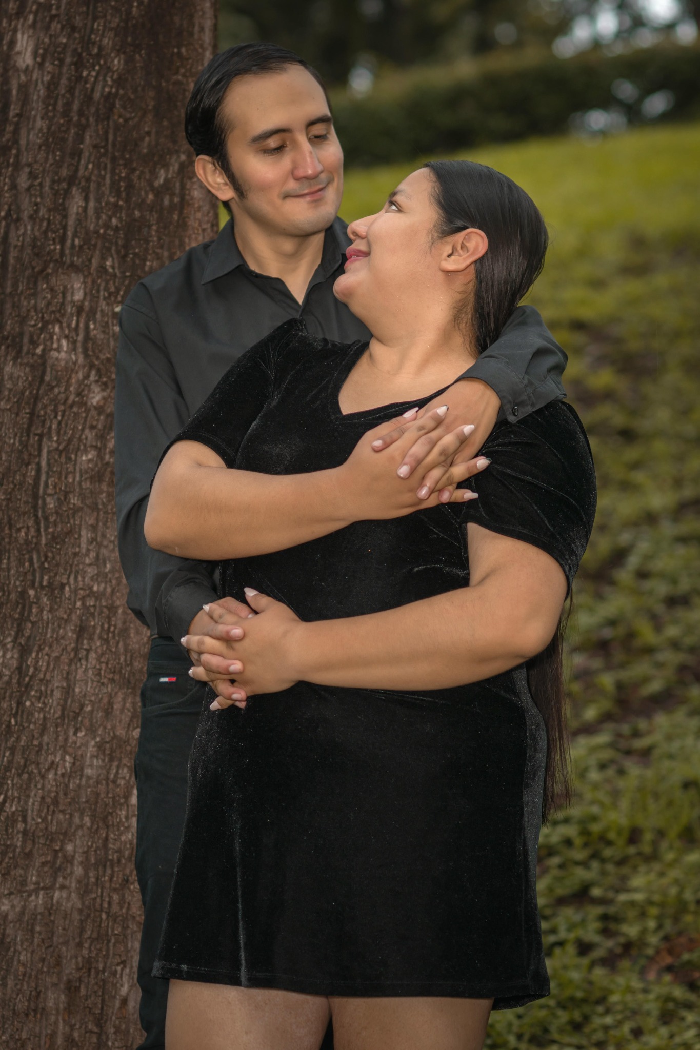 Keily y Leobardo mirándose junto a un árbol